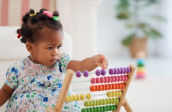 cute african american baby girl playing colorful abacus toy at home infant playing with colorful abacus toy